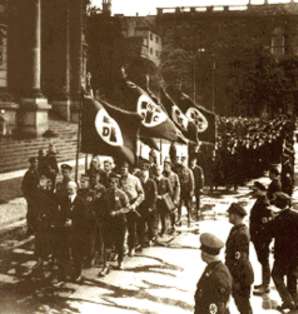 Aufmarsch der "Deutschen Christen" vor der Berliner Dom vor einer Ehrengarde von SS-Leuten. An der Spitze Mitglieder der Bewegung in Partei- und SA-Uniformen. Danach folgen die Pastoren. Die Fahnen sind stark den Fahnen der Nationalsozialisten nachempfunden.